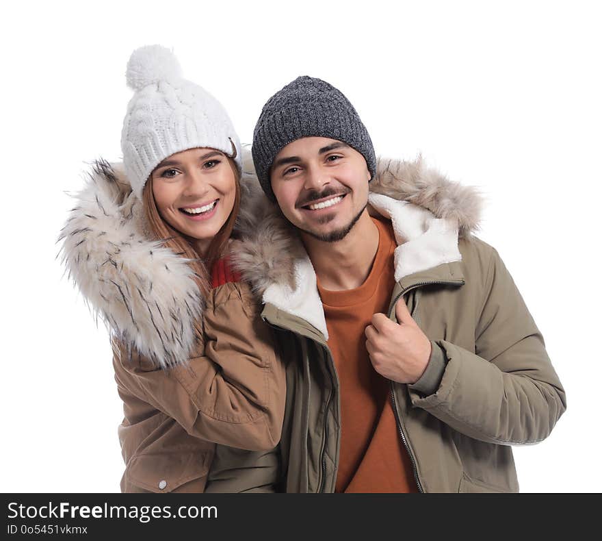 Young couple wearing warm clothes on white background. Ready for winter vacation