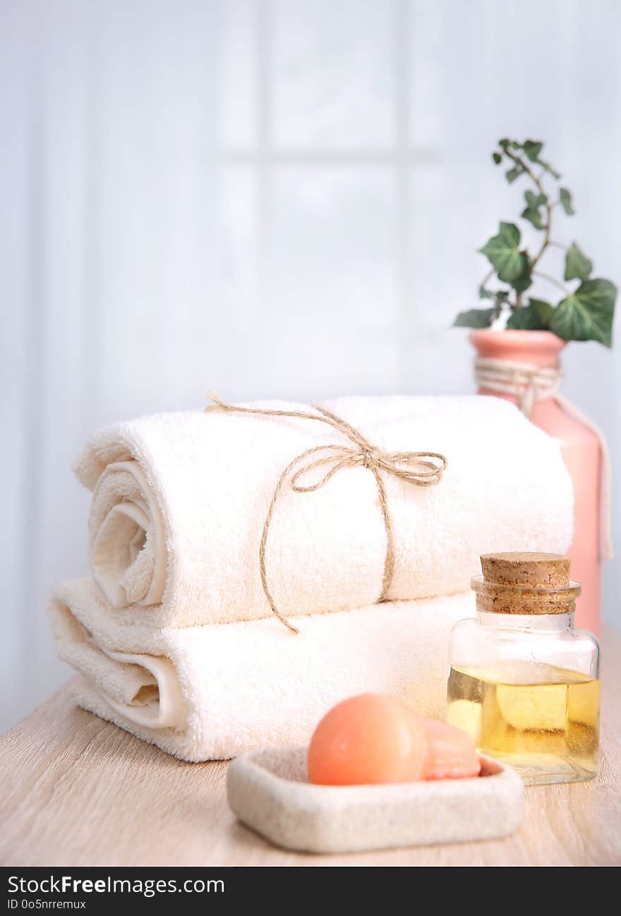 Fresh towels,soap and oil bottle on table.Hotel bathroom items,spa body care. Fresh towels,soap and oil bottle on table.Hotel bathroom items,spa body care.