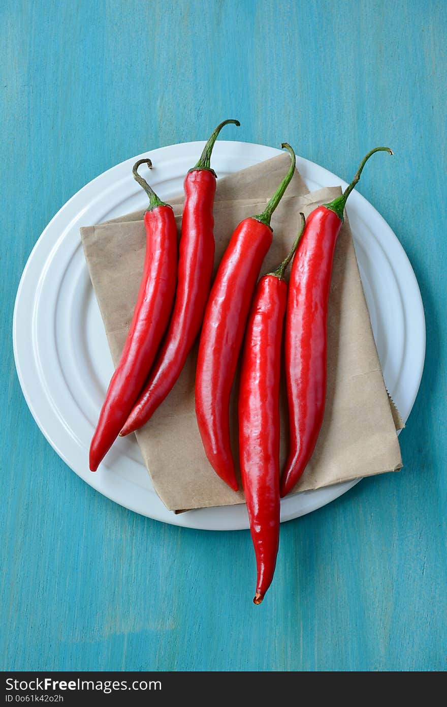 Red chili on dish and wooden background.