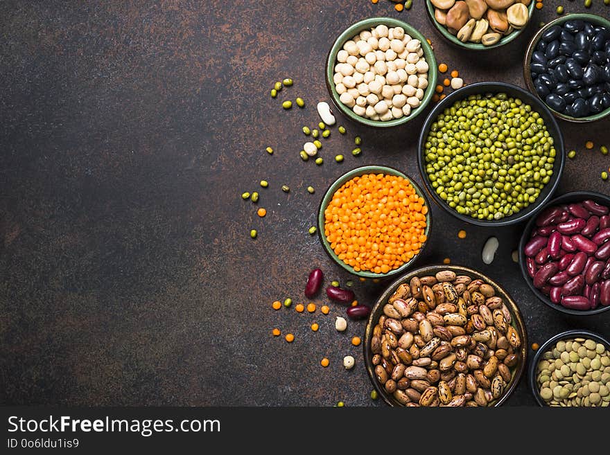 Legumes, lentils, chikpea and beans assortment in different bowls on stone table. Top view with copy space. Legumes, lentils, chikpea and beans assortment in different bowls on stone table. Top view with copy space.