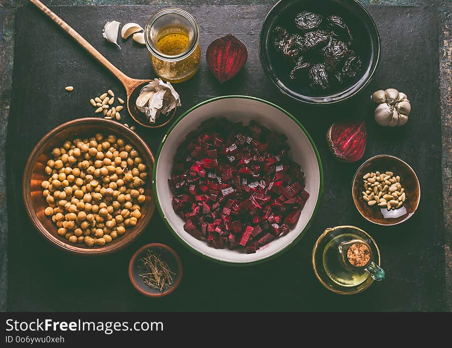 Diced beet and salad ingredients with pine nuts, chickpeas and prunes on dark background, top view with copy space for your design. Healthy , low calories food and diet and detox eating concept