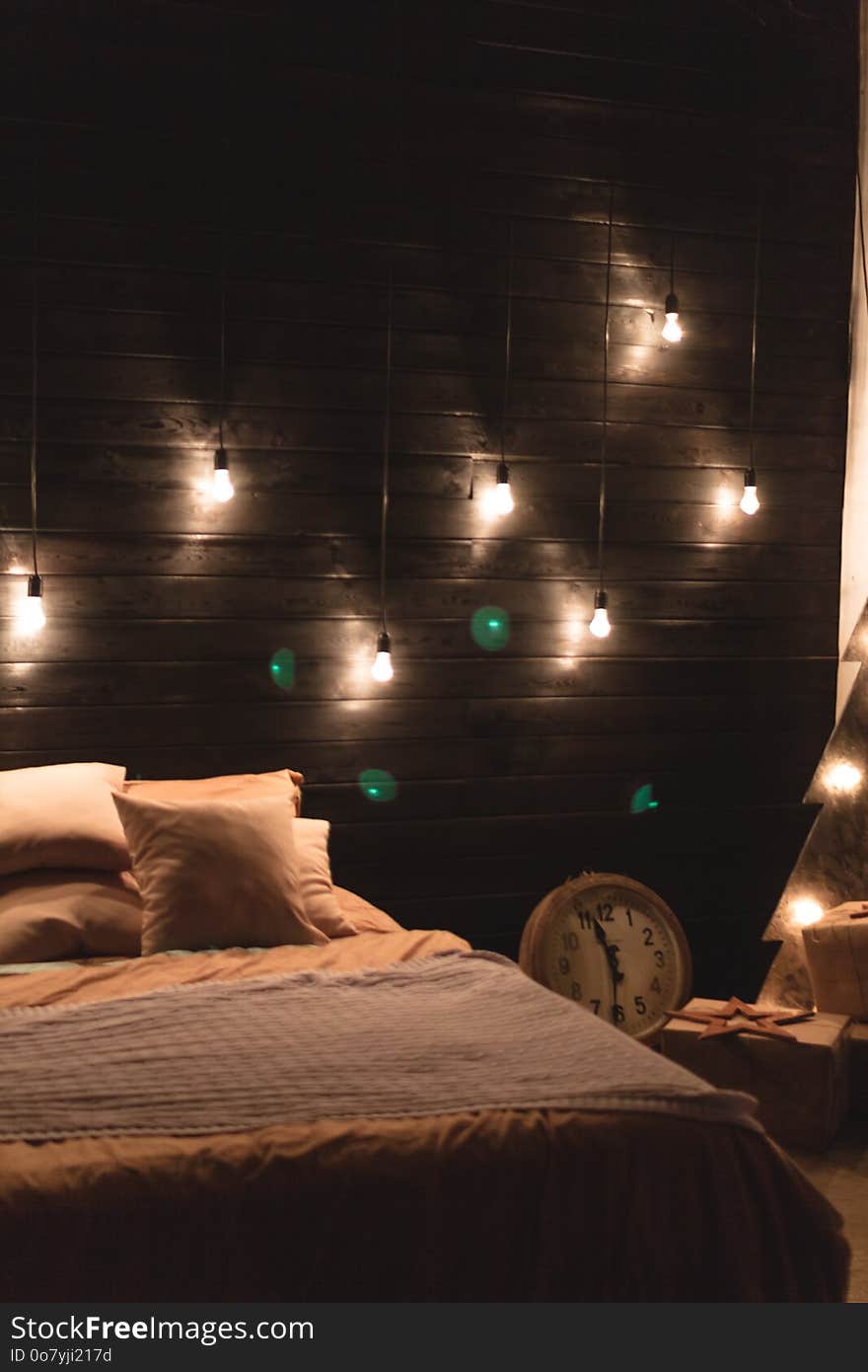 Scandinavian style bedroom interior under Christmas. Textural wooden bed in the style of New Year`s Rustic decorated.