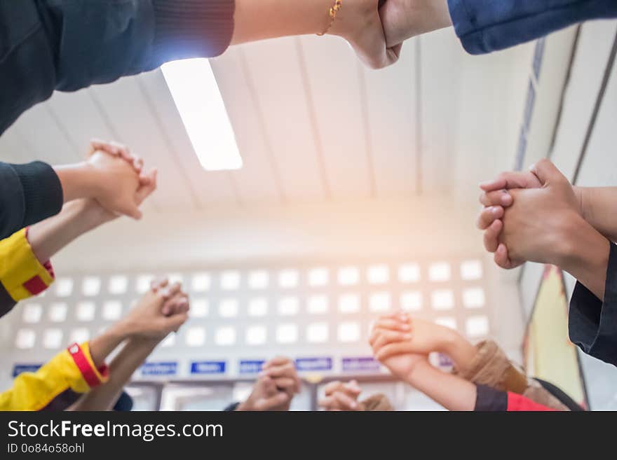 Unity and teamwork Concept: Blurred of Group students hands together in classroom. View of Asian young men putting their hand