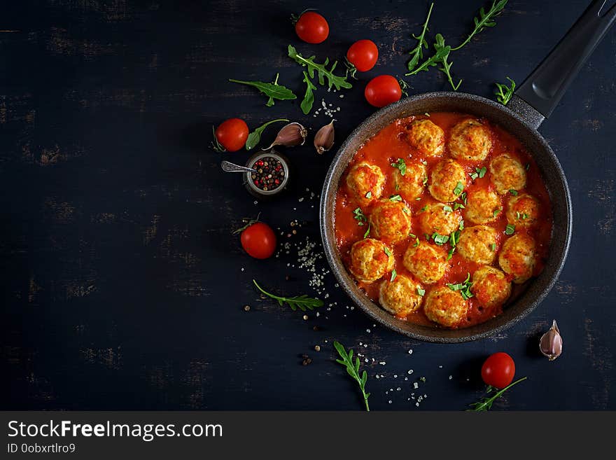 Chicken meatballs with tomato sauce in a pan. Dinner. Top view. Dark background