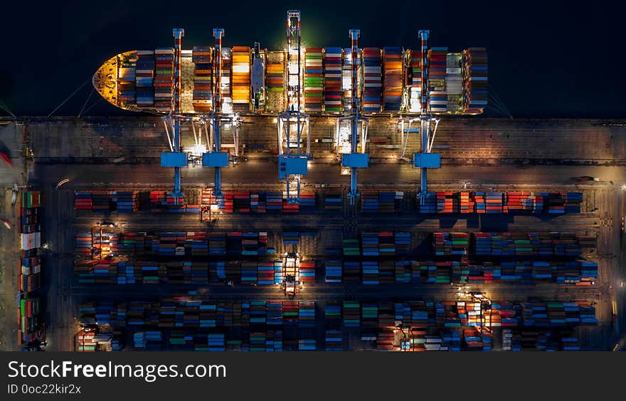 Container ship in import export business logistic at night, Aerial top view of container ship.