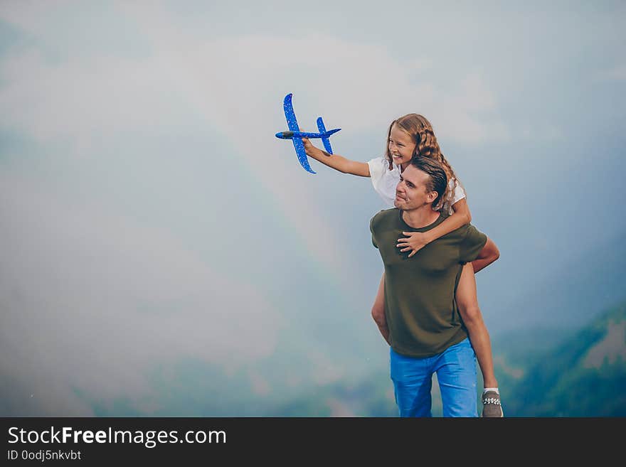 Beautiful little girl and young father in mountains in the background of fog