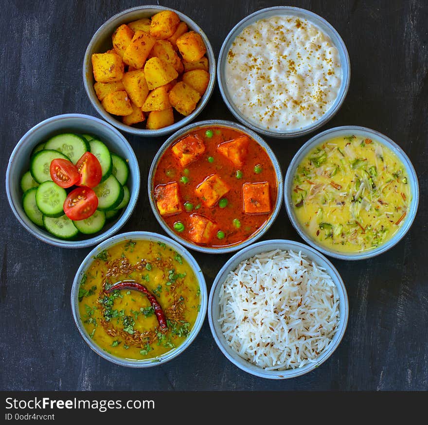 North Indian cuisine - matar paneer or cottage cheese curry,fried potato sides,yogurt dip,kheer dessert,jeera rice,dal fry lentils. North Indian cuisine - matar paneer or cottage cheese curry,fried potato sides,yogurt dip,kheer dessert,jeera rice,dal fry lentils