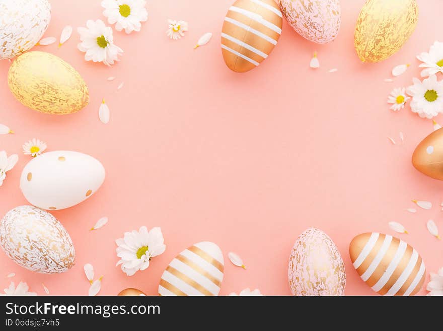 Flat Lay of Golden Easter Eggs with small flowers and petals on pink background. Easter background or easter concept. Flat Lay of Golden Easter Eggs with small flowers and petals on pink background. Easter background or easter concept