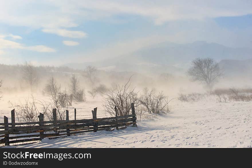 Winter field in a storm in mountains