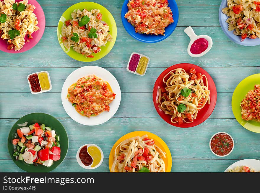 Pasta with vegetables and sauce on a table. Spaghetti on a plate. Mediterranean food