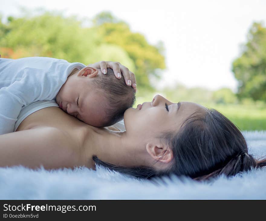 Beautiful mother and her son baby sleeping together in the park, Healthcare and medical love.