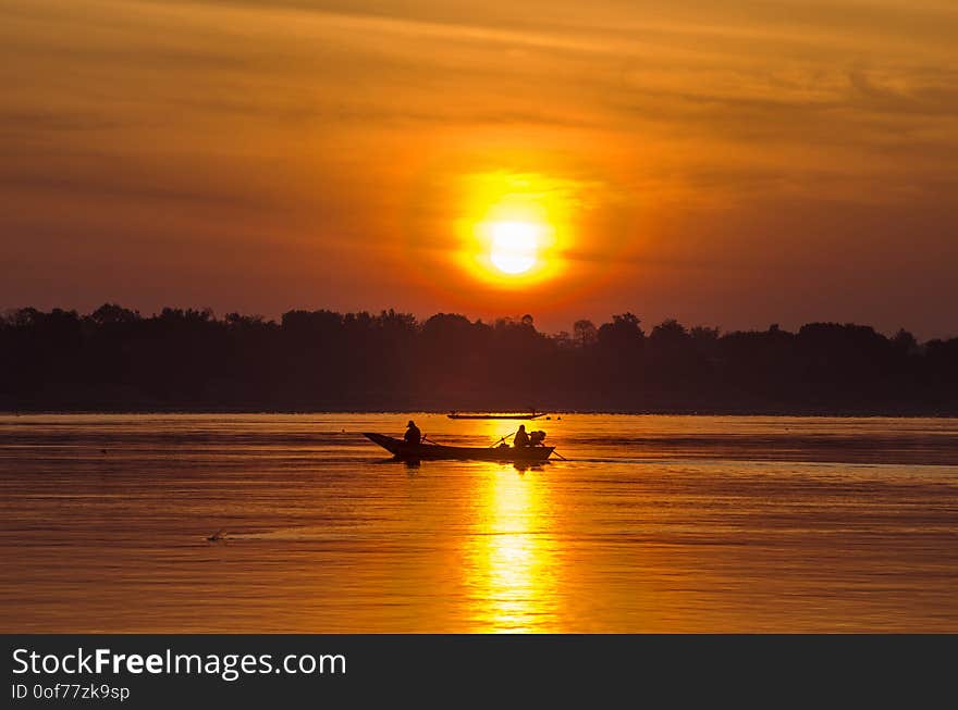 Long tail fisherman boat in Khong river between Thailand and Lao sunrise