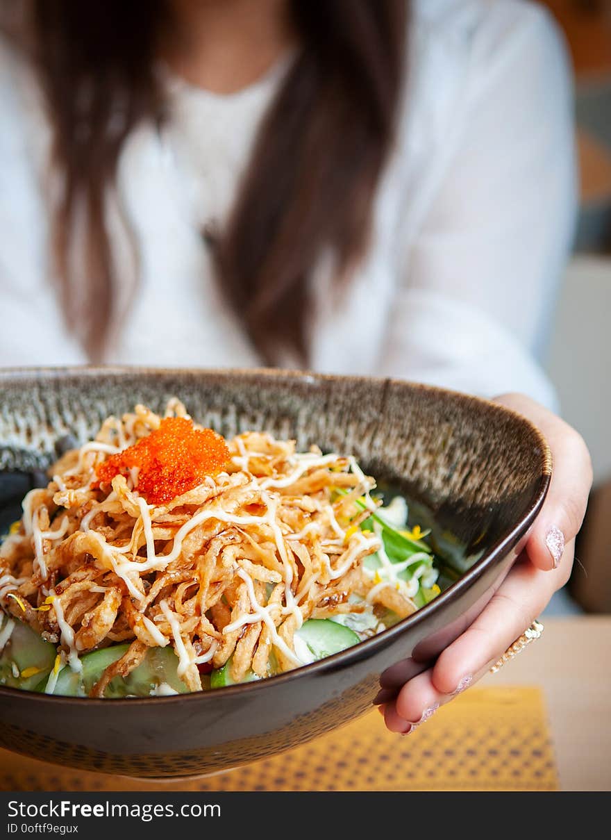 Woman holding a bowl of crispy fried shredded chiken salad, Japanese style salad with vegetables and shrimp roe on top. Woman holding a bowl of crispy fried shredded chiken salad, Japanese style salad with vegetables and shrimp roe on top