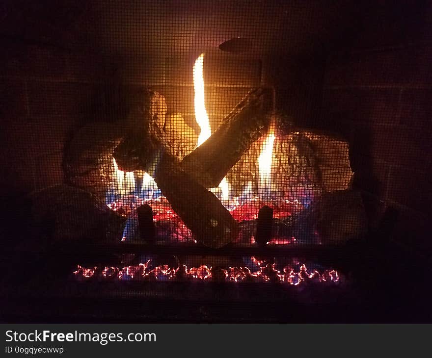 Gas fireplace with flame and fire and logs and metal grate