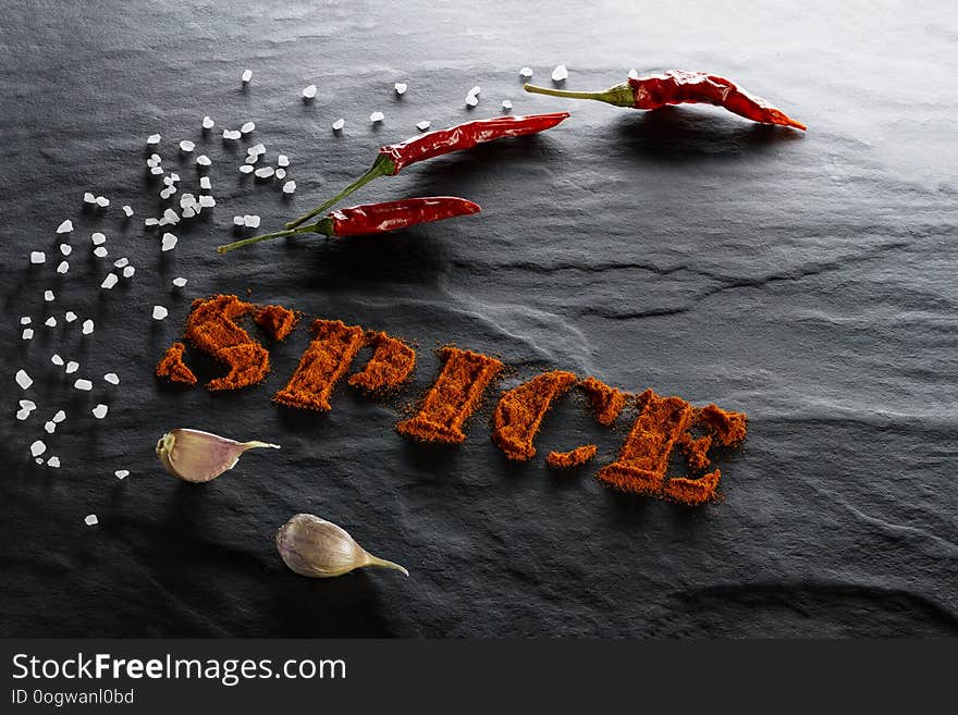 Spice. Ground paprika, chili pepper, garlic and sea salt close up on a black textural background