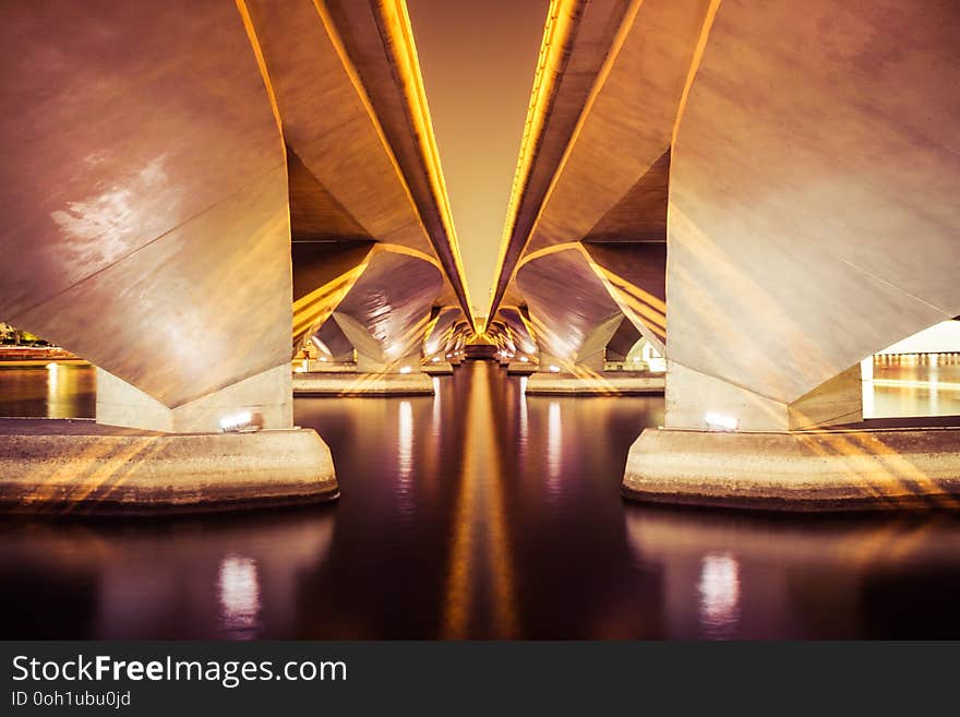 Symmetric Bridge over Water at Night in Black and White