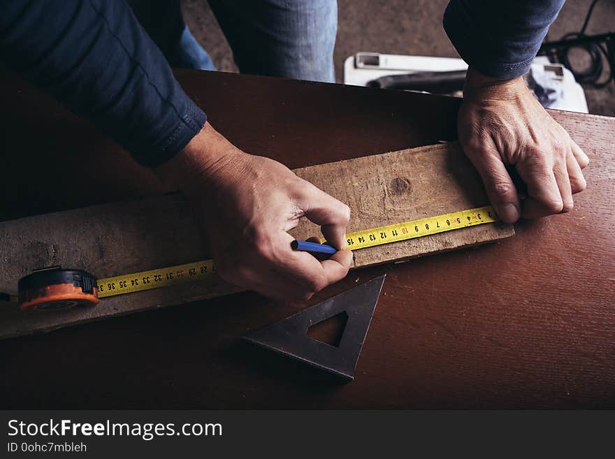 Amateur carpenter measures the board