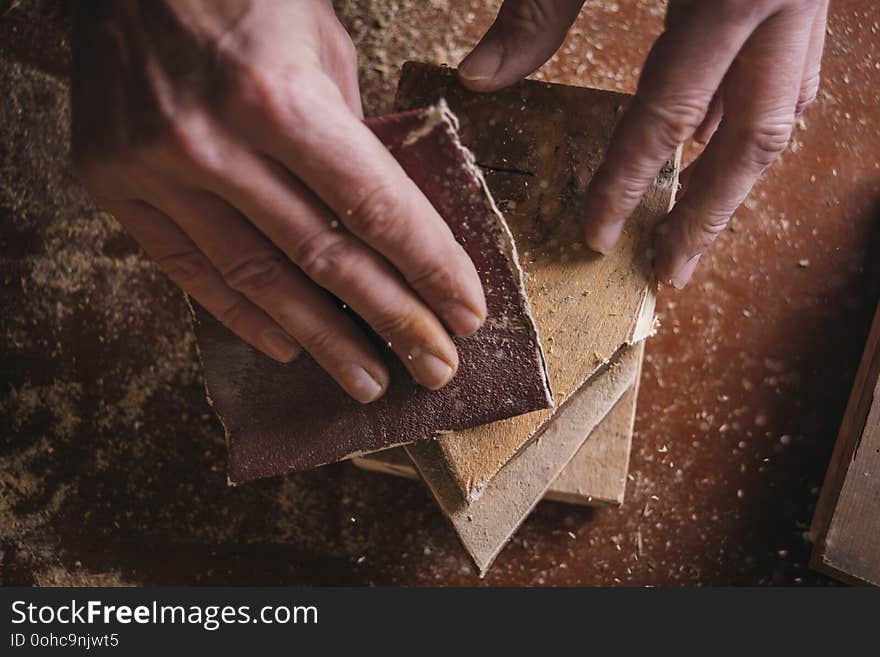 Amateur carpenter uses sanded paper on wood