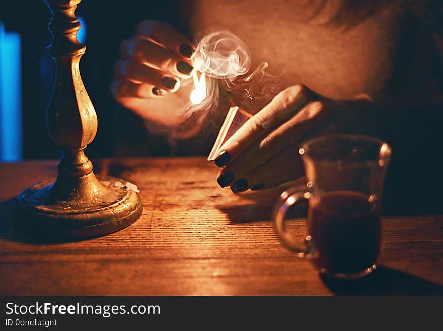 Young beautiful fortune teller woman in a mysterious setting with coffee and candles. Young beautiful fortune teller woman in a mysterious setting with coffee and candles