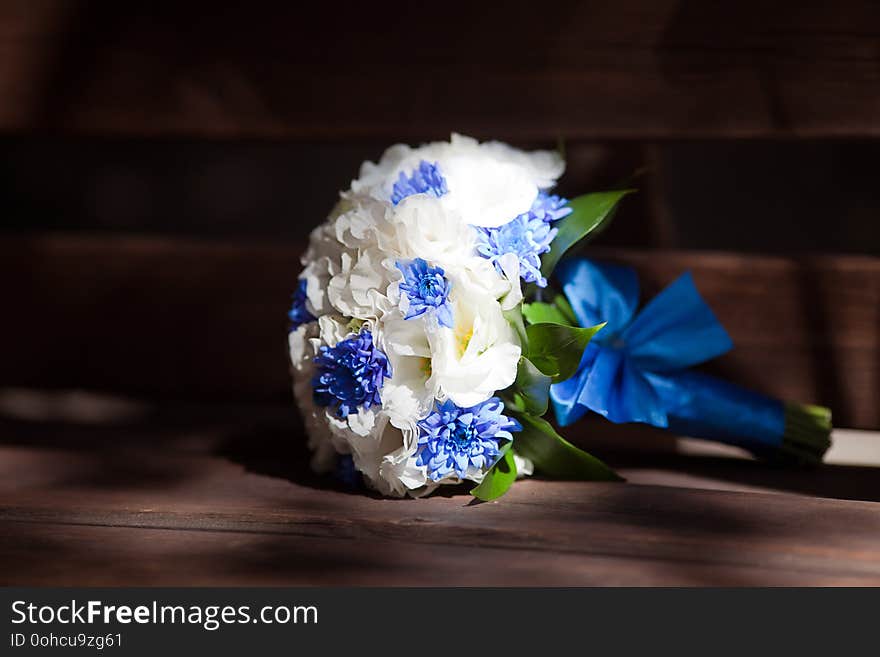 Mockup bouquet with delicate flowers and green leaves on a black background. blue ribbon