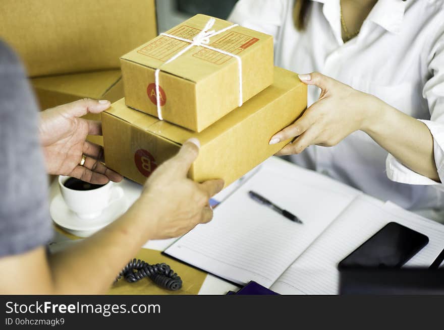 Startup working workplace business owner prepare to deliver goods in cardboard box to delivery man who has handed over,Concept