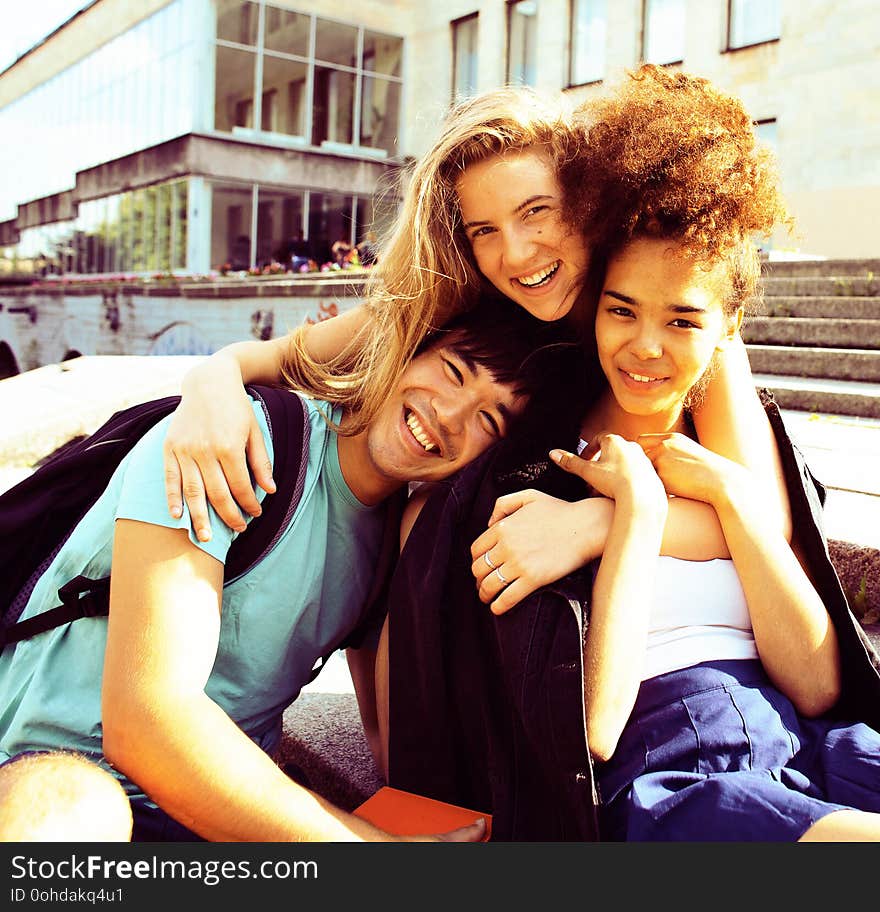 Cute group of teenages at the building of university with books huggings, back to school. Cute group of teenages at the building of university with books huggings, back to school