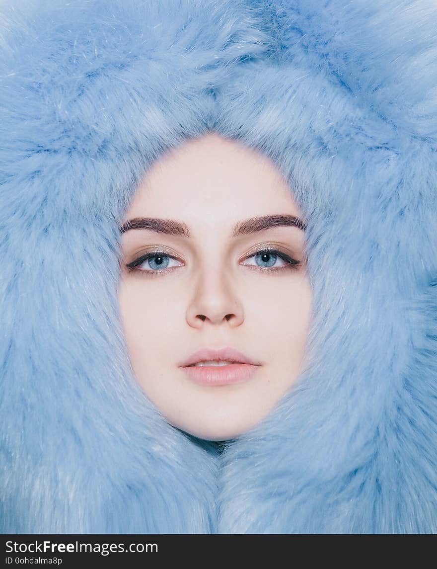 Face girl contented in soft fur coat with a hood. Face girl contented in soft fur coat with a hood