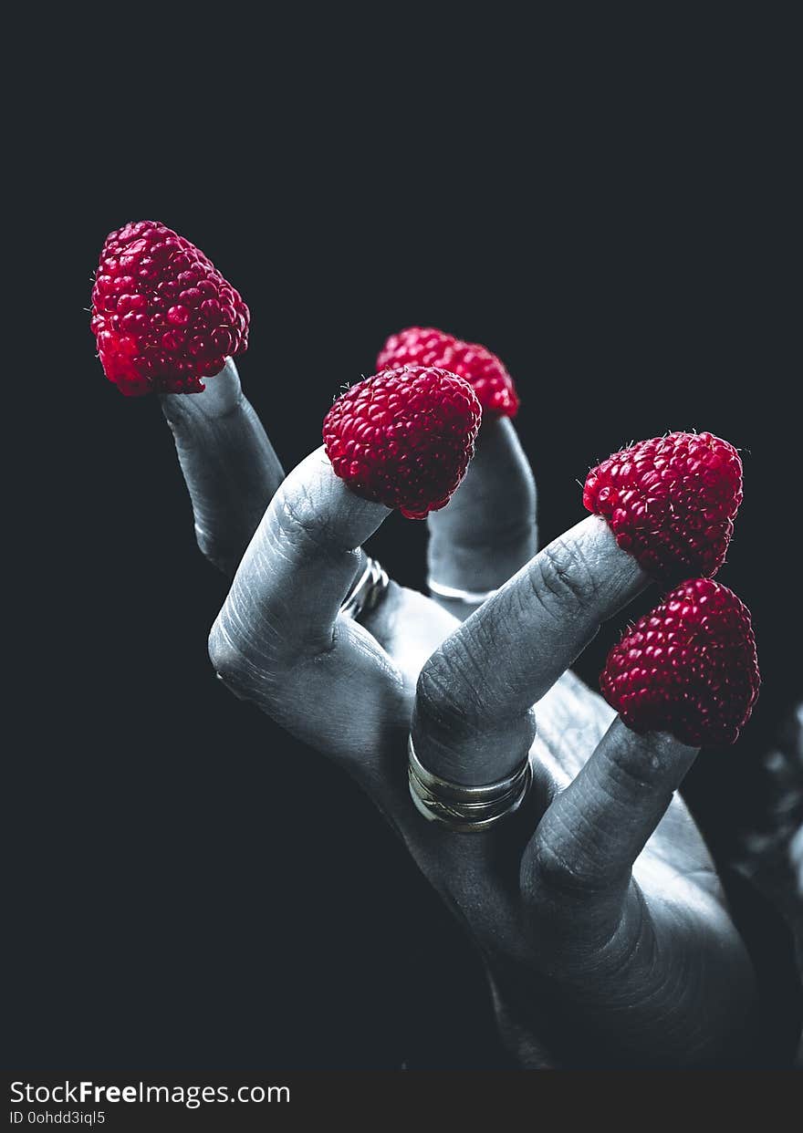 Fingers with raspberry