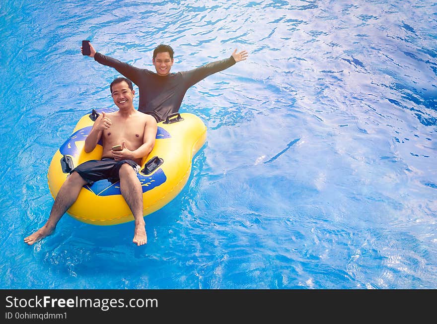 Friends of two enjoying in the pool floating using inflatable buoy. Friends of two enjoying in the pool floating using inflatable buoy