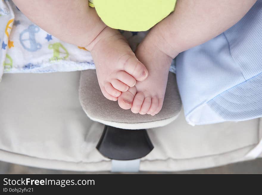 Newborn baby chubby feet over on i-size baby car over pushchair. Overhead shot. Newborn baby chubby feet over on i-size baby car over pushchair. Overhead shot