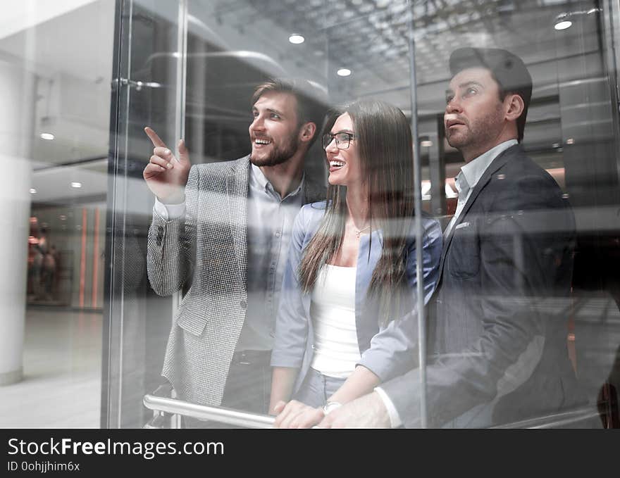 Group Of Business People Standing In Glass Elevato