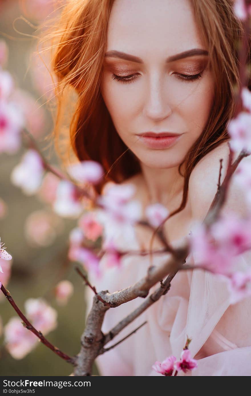 Beautiful Young Girl Under The Flowering Pink Tree