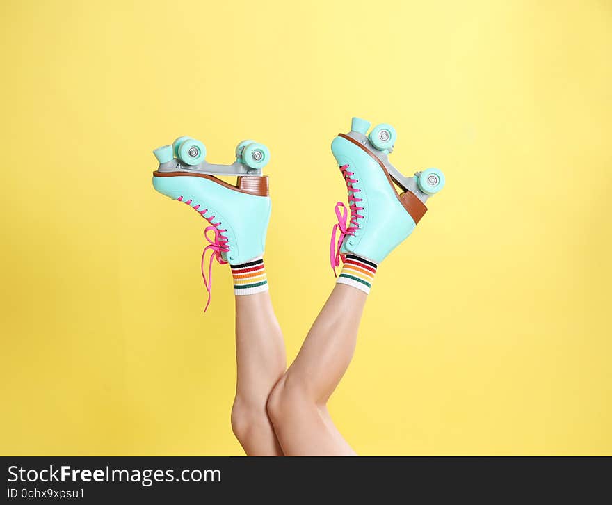 Young Woman With Retro Roller Skates On Color Background