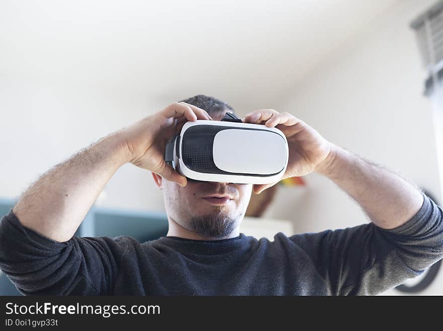 young man using virtual reality headset, technology, male, vr, device, 3d, adult, glasses, modern, innovation, entertainment, fun, video, digital, futuristic, experience, business, excited, vision, caucasian, simulation, hi-tech, enjoying, white, contemporary, casual, person, watch, indoors, home, play, background, beard, handsome, smile, videogame, shirt, startup, wearable, gear, looking, activity, display, comfortable