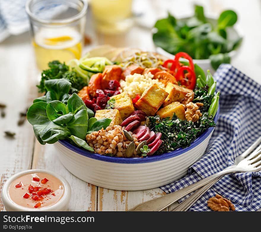 Buddha bowl of mixed vegetables,tofu cheese and groats. Healthy and nutritious vegan meal.