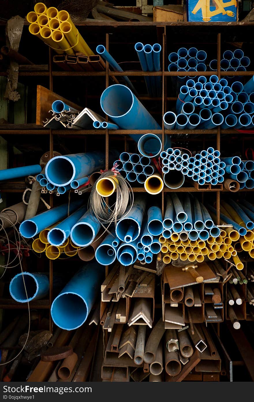 Blue and yellow PVC pipes in warehouse.