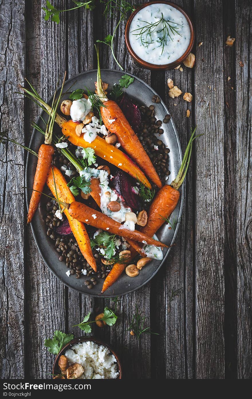 Lentil Salad with Roasted Carrots, Beetroots and Feta Cheese on wooden background