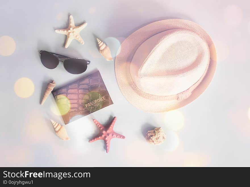 Summer vacation concept. Hat, sunglasses, passport, starfishes and seashells on blue background.