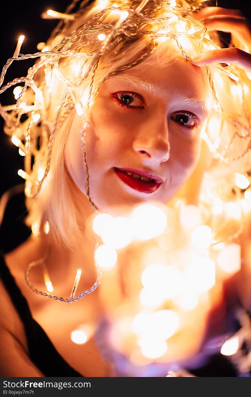 portrait of a girl with a garland on black background.