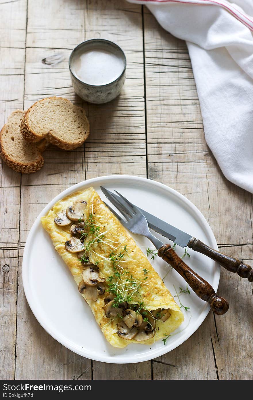 Vegetarian breakfast, omelette with mushrooms and cress, served with rye bread and coffee with milk. Rustic style, selective focus