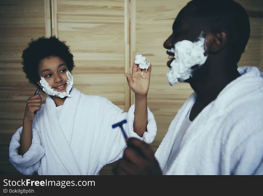 Little black boy stains father with shaving foam