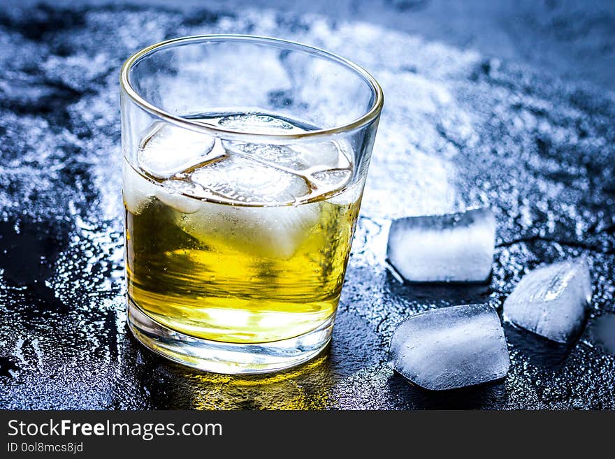 Glass of whiskey on dark background close up