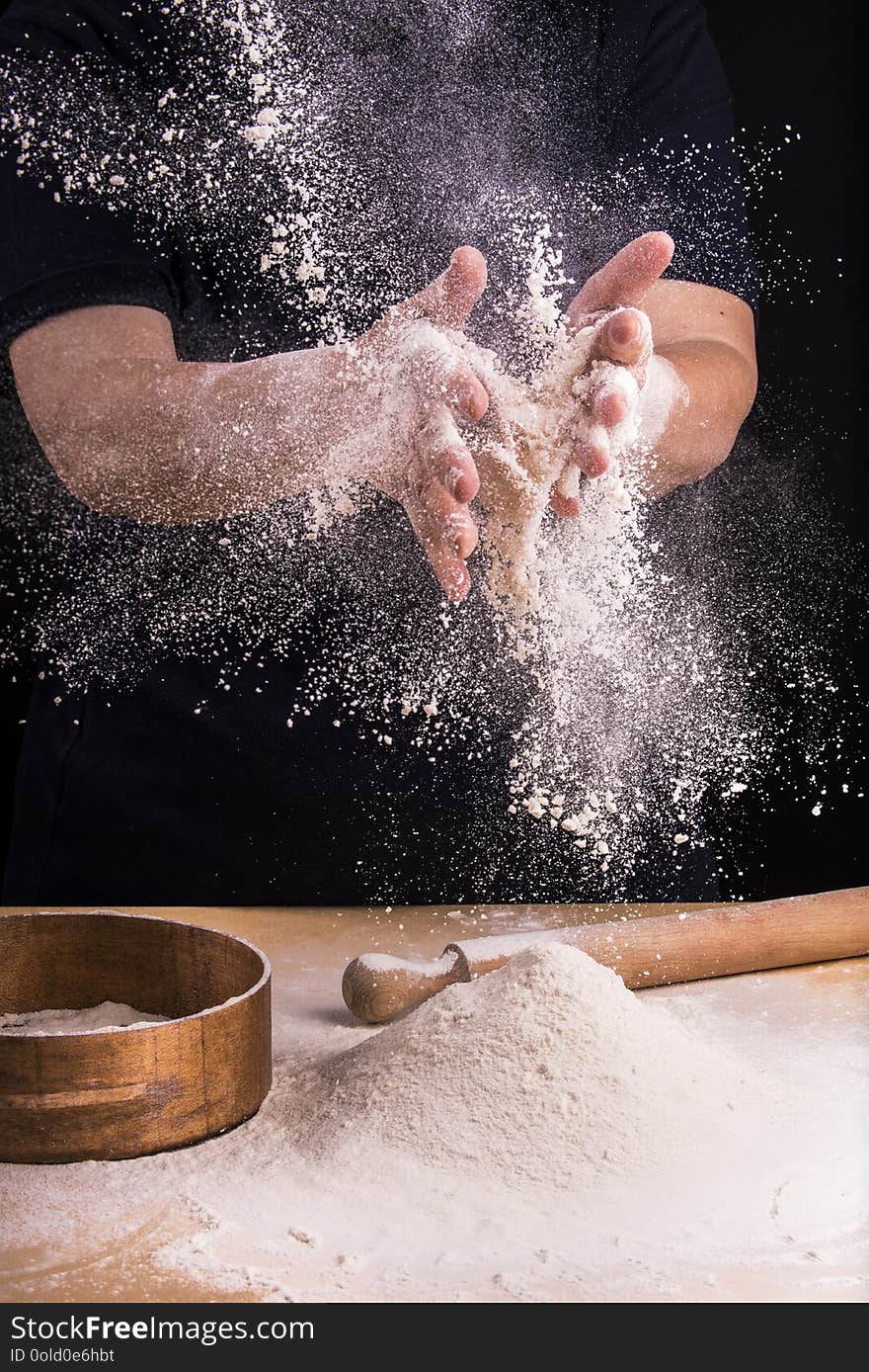 Closeup of hands of a woman who juggles to sift flour for the dough preparation. Closeup of hands of a woman who juggles to sift flour for the dough preparation