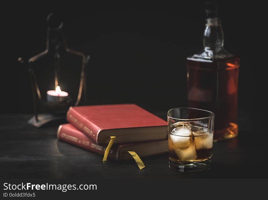 A glass of whiskey and a good book - time to relax - photo in retro style