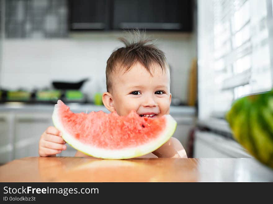 Cute Little Boy Eating Watermelon In The Kitchen