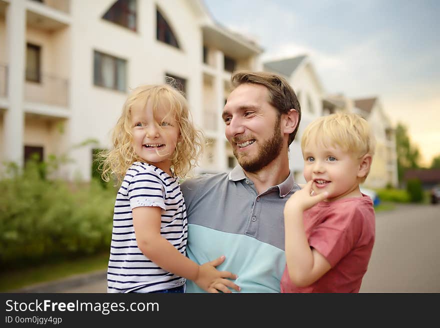 Young happy father with two cute little children walking in summer. Quality family time