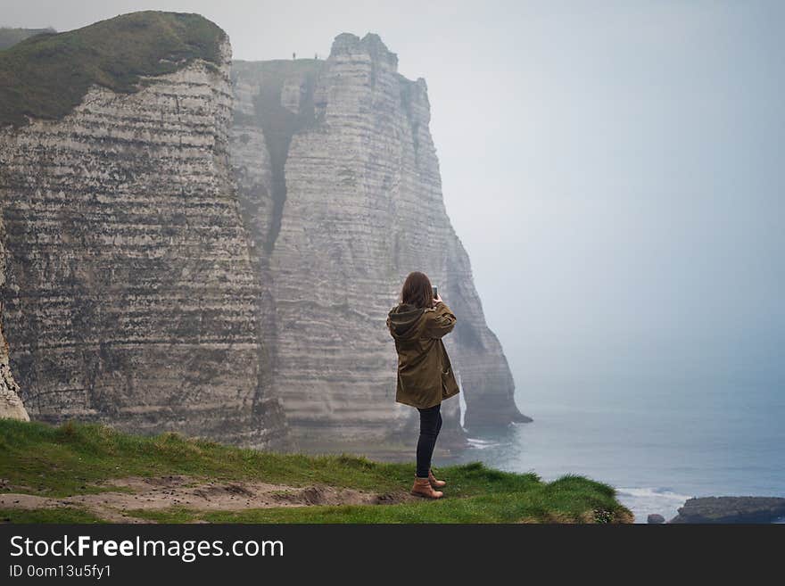 Girl standing at the edge of rock in the Etretat. France. Girl standing at the edge of rock in the Etretat. France