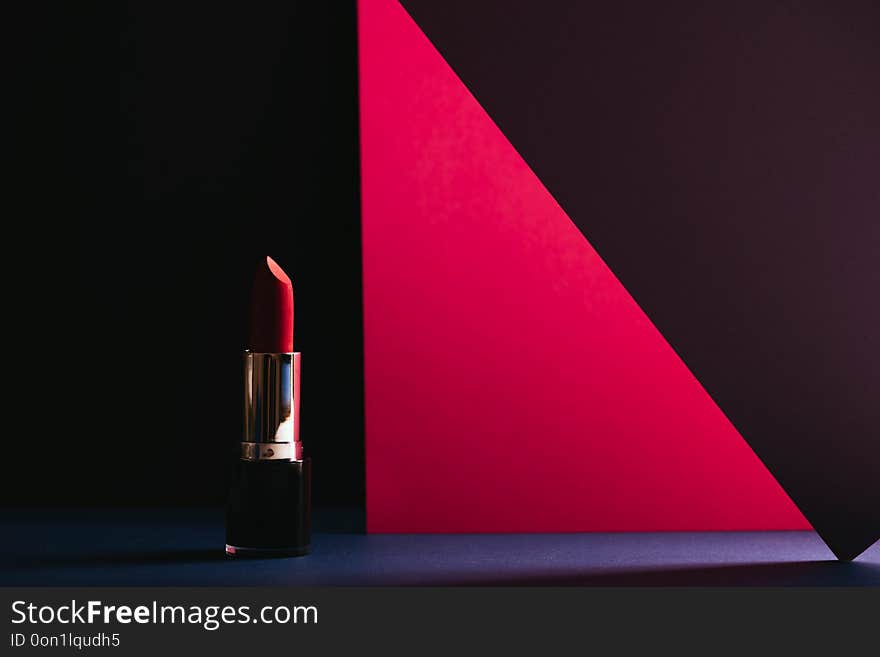 Elegant make-up stills, pink lipstick on colorful geometric background. Product and make up contemporanean concept. front view