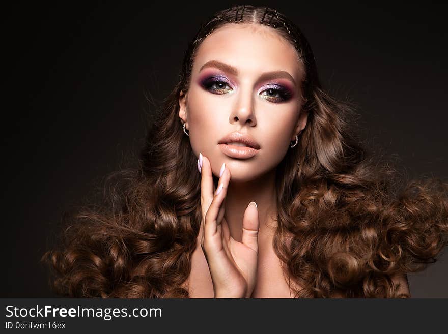 Beautiful young brunette with make up and curly hair