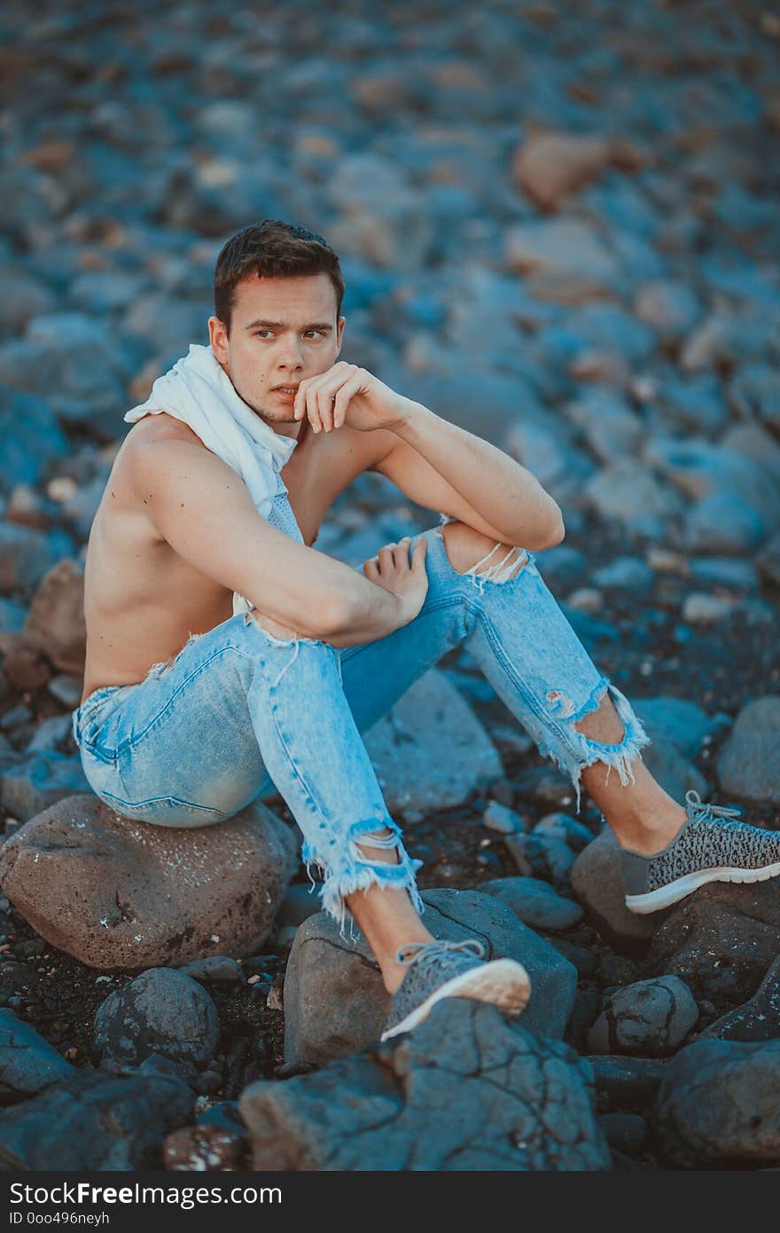 Photography of young man on the stone beach